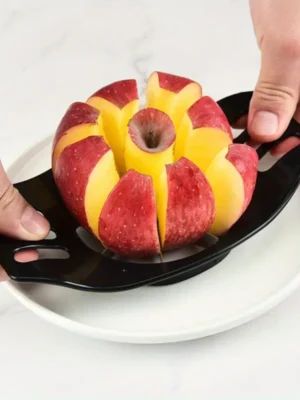 A person using a black-handled apple corer and cutter to slice a red apple into evenly sized wedges on a white plate.